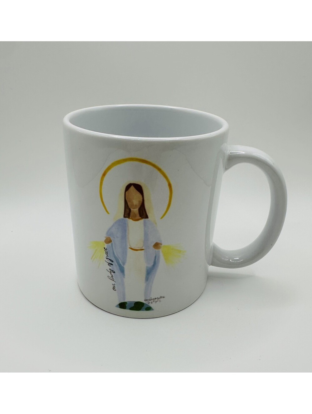 White ceramic coffee mug featuring a devotional image of the Virgin Mary